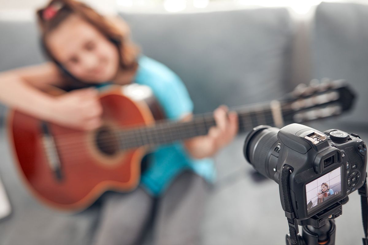 Child guitarist making video lessons and tutorials for internet vlog (Getty Images/m-gucci)